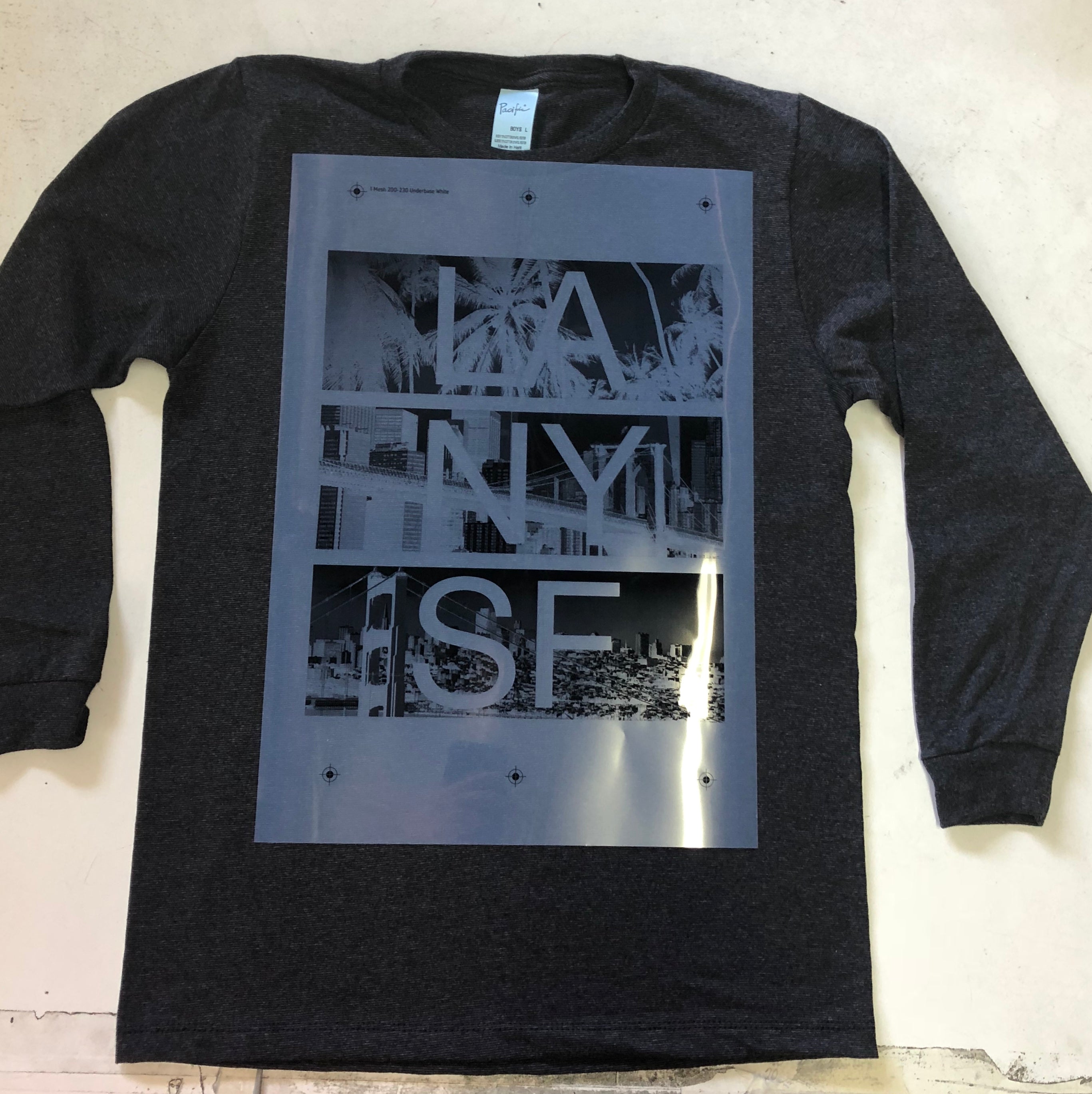 Black long-sleeve shirt with graphic design on a light wooden surface
